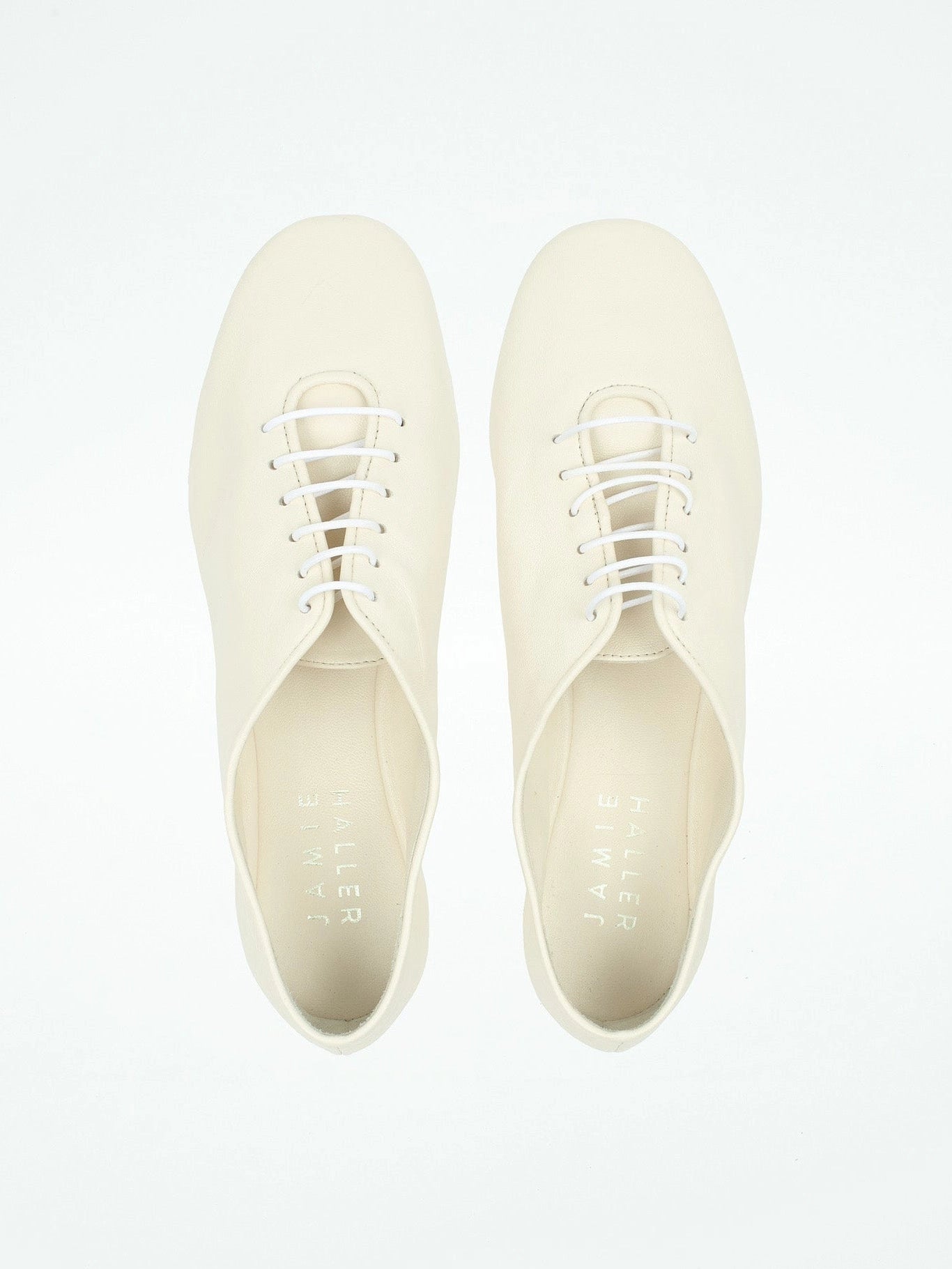 Pair of white sneakers on a light gray background