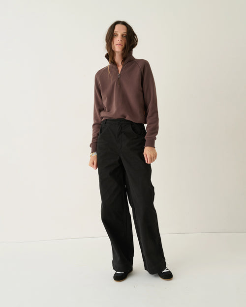 Model wearing Jamie Haller The Quarter Zip in brown Japanese French terry with a stand collar, quarter-zip front, and relaxed fit.