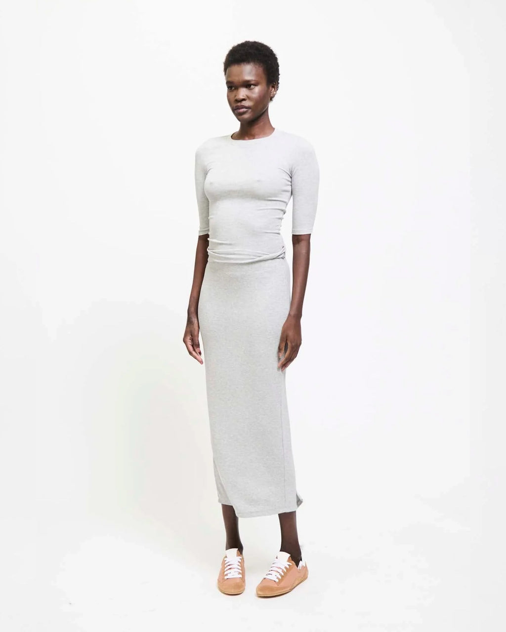 Model wearing Jamie Haller Rib Pencil Skirt in heather grey with a slim, straight silhouette and ankle-length hem.