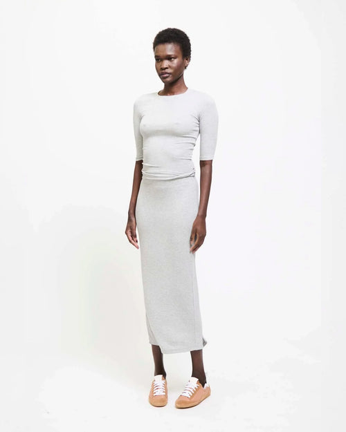 Model wearing Jamie Haller Rib Pencil Skirt in heather grey with a slim, straight silhouette and ankle-length hem.