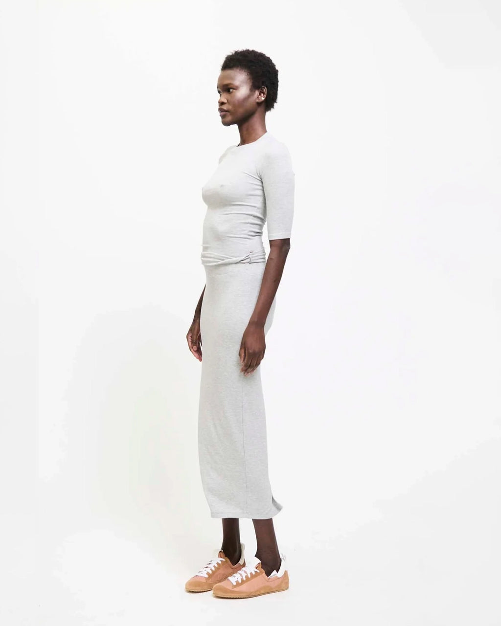 Model wearing Jamie Haller Rib Pencil Skirt in heather grey with a slim, straight silhouette and ankle-length hem.