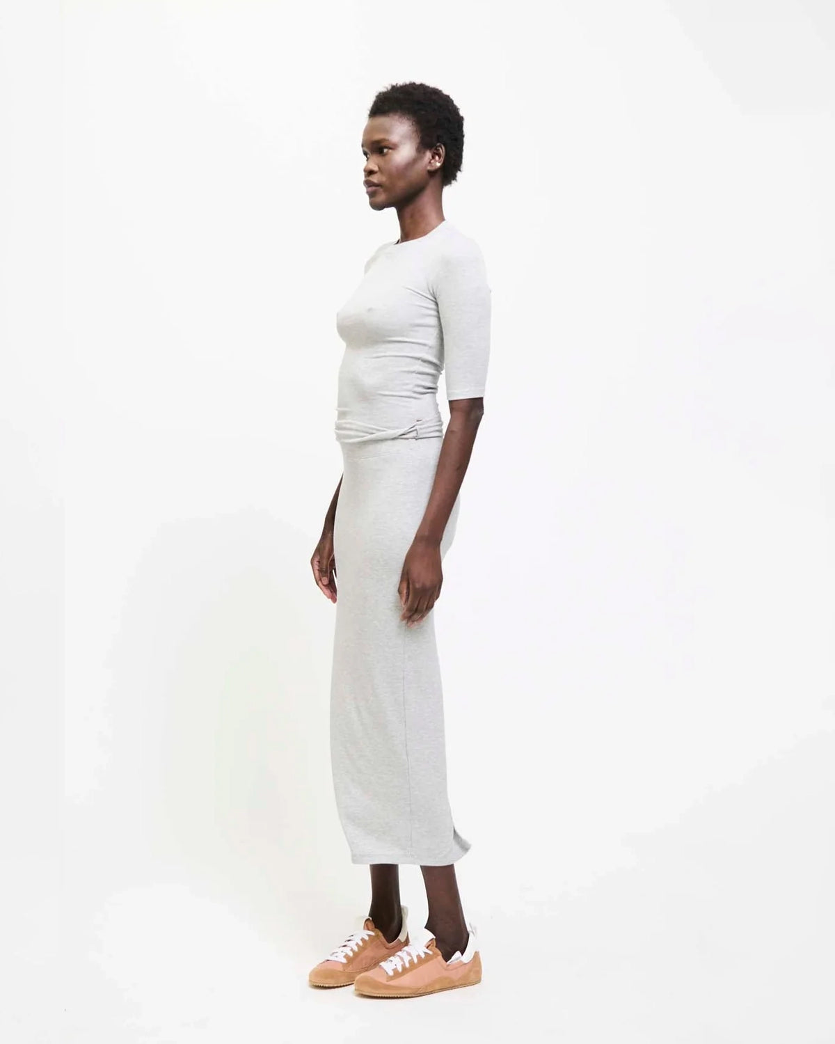 Model wearing Jamie Haller Rib Pencil Skirt in heather grey with a slim, straight silhouette and ankle-length hem.