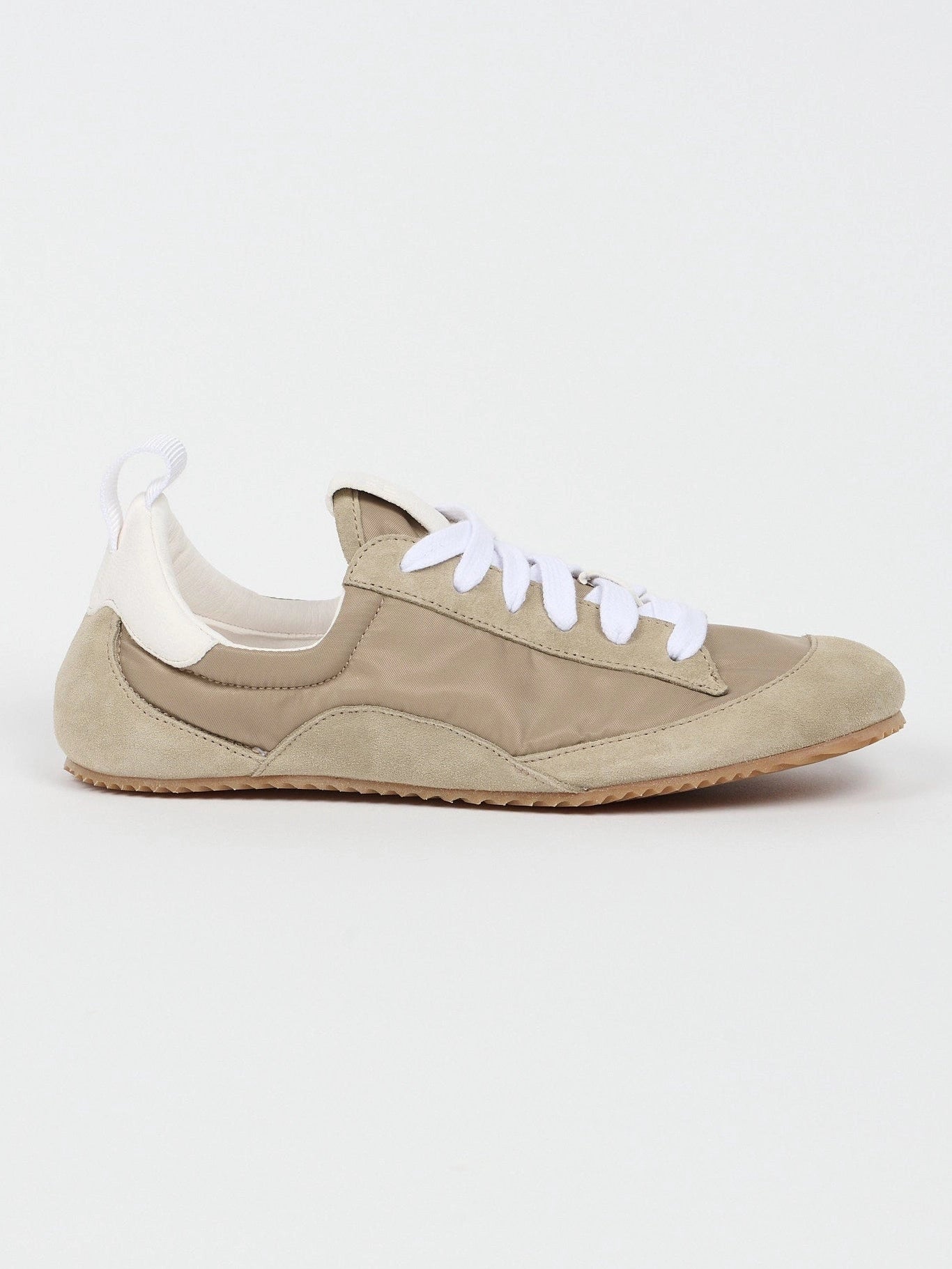 Beige sneaker with white laces on a light gray background