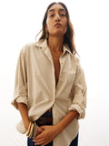 Woman wearing a striped shirt with rolled-up sleeves on a white background