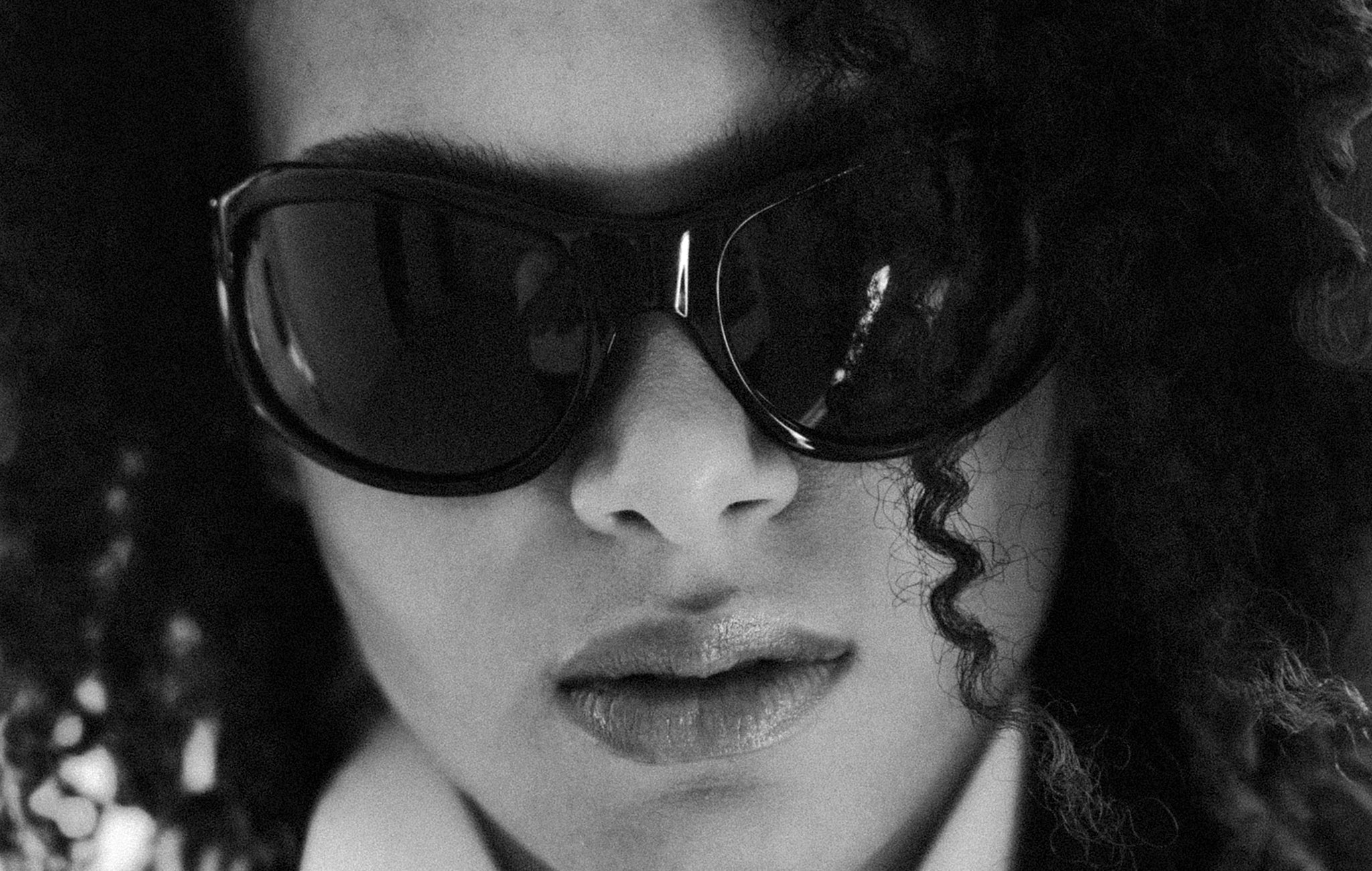 Person wearing large sunglasses with a blurred background