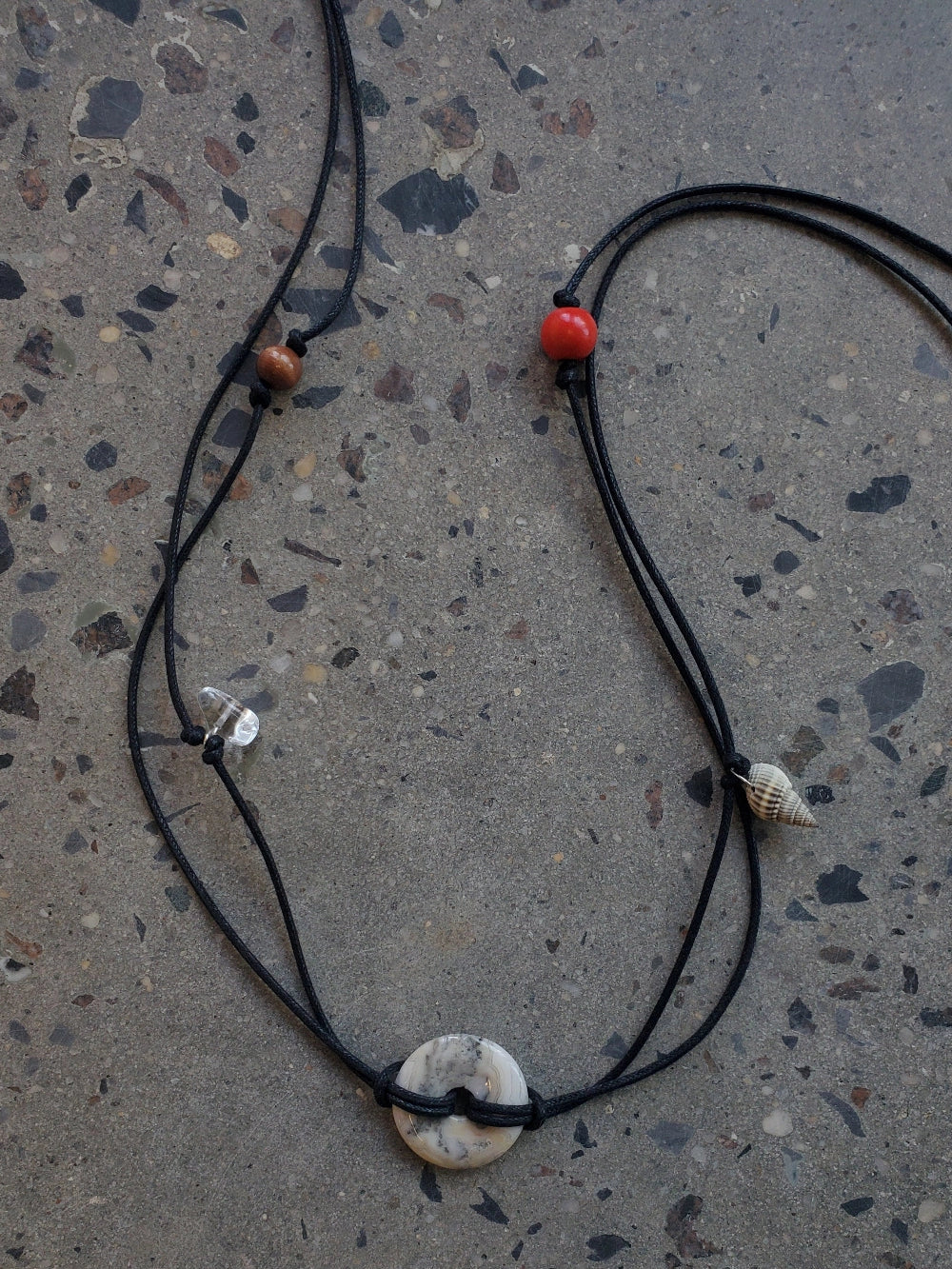 NOMIA cord belt in black braided cotton with lace agate stone disc pendant and mixed bead details including shell and wood.
