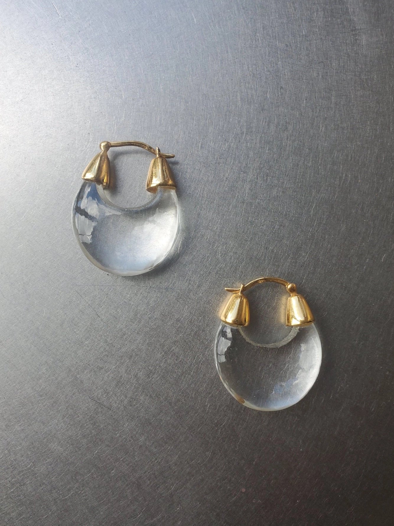 NOMIA crystal hoop earrings with carved teardrop crystal drops and gold vermeil hinged hoops.