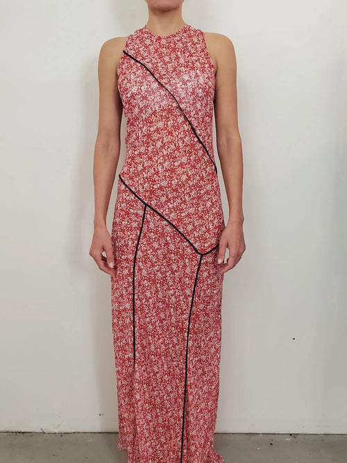 NOMIA paneled maxi bias dress in poppy floral chiffon with contrast piping, fitted through the bodice with a fluid full-length skirt and asymmetric hem.