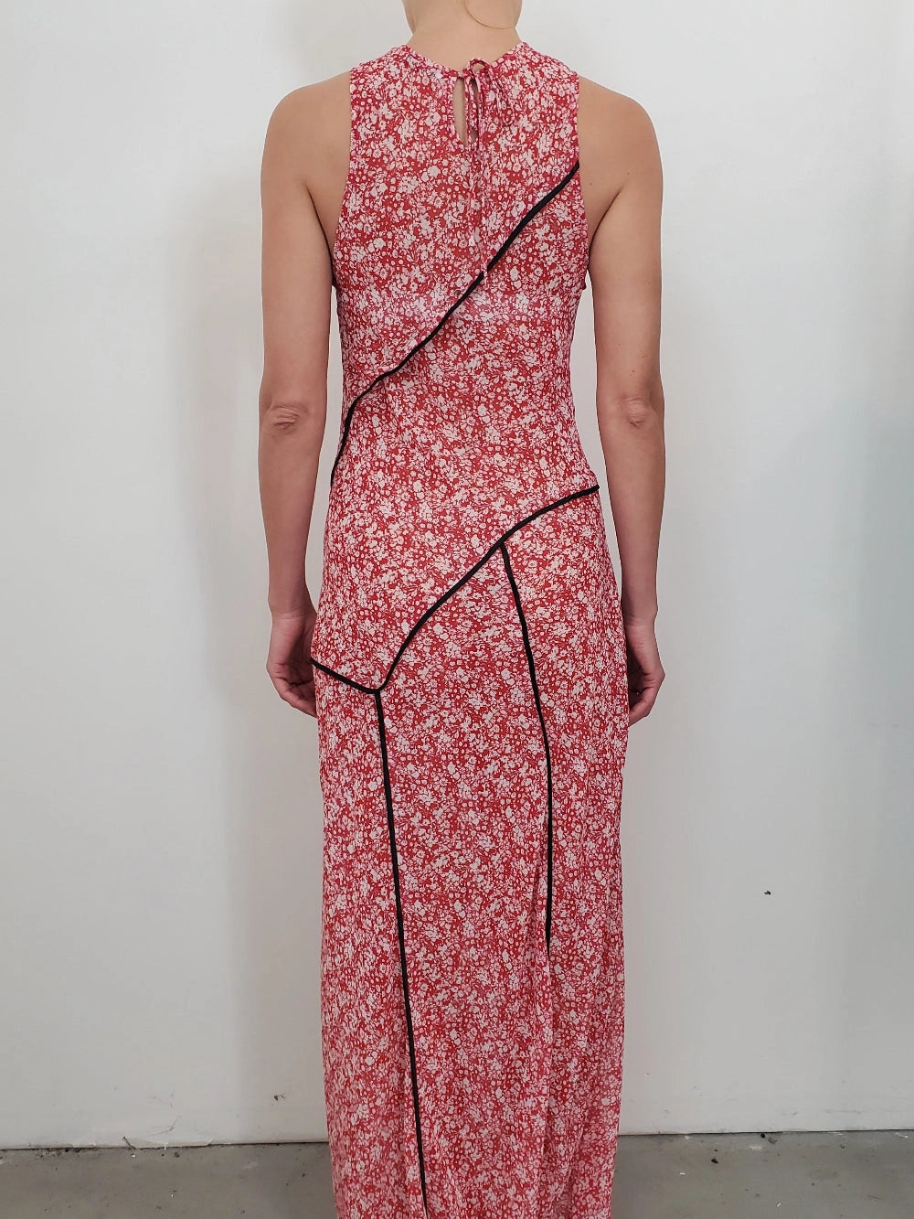 NOMIA paneled maxi bias dress in poppy floral chiffon with contrast piping, fitted through the bodice with a fluid full-length skirt and asymmetric hem.