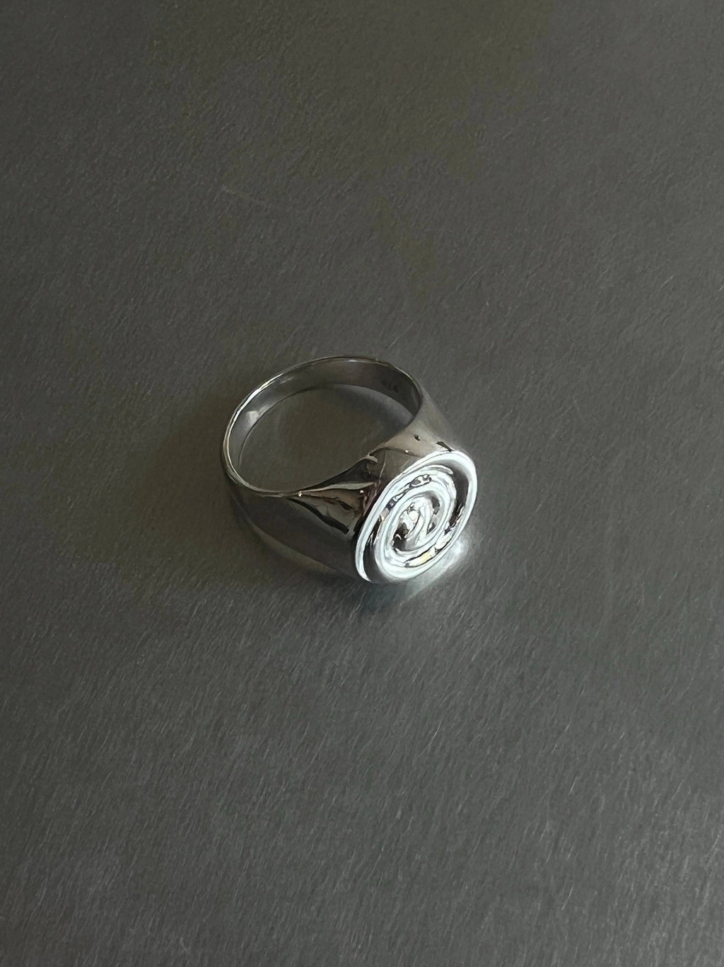 NOMIA Spiral Signet Ring in sterling silver with a polished finish and carved spiral face.