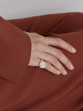 NOMIA Spiral Signet Ring worn on hand.