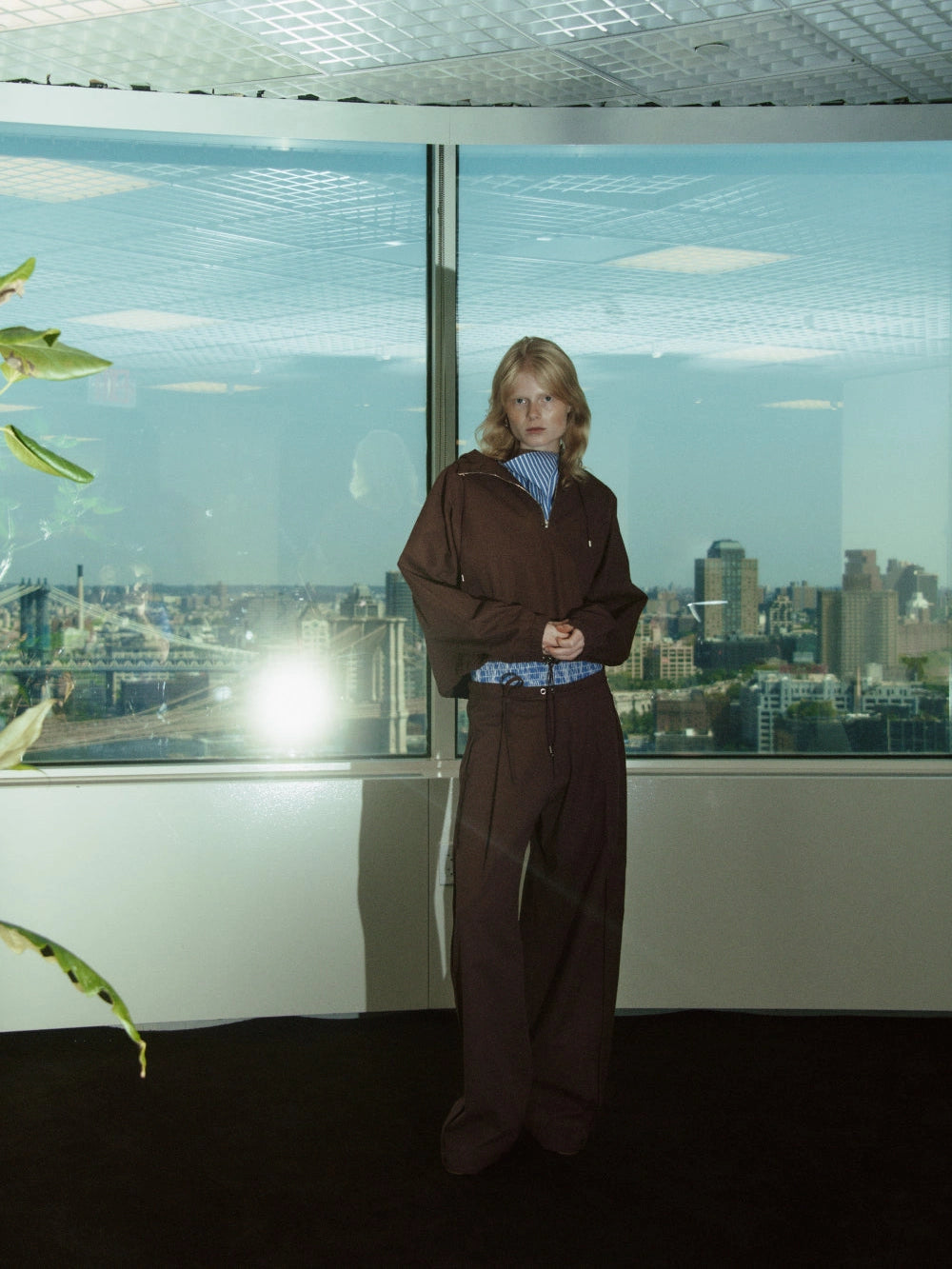 NOMIA Zip Hooded Pullover in russet with an oversized cropped fit, drawcord hem and elastic cuffs, worn with matching wide leg trousers.