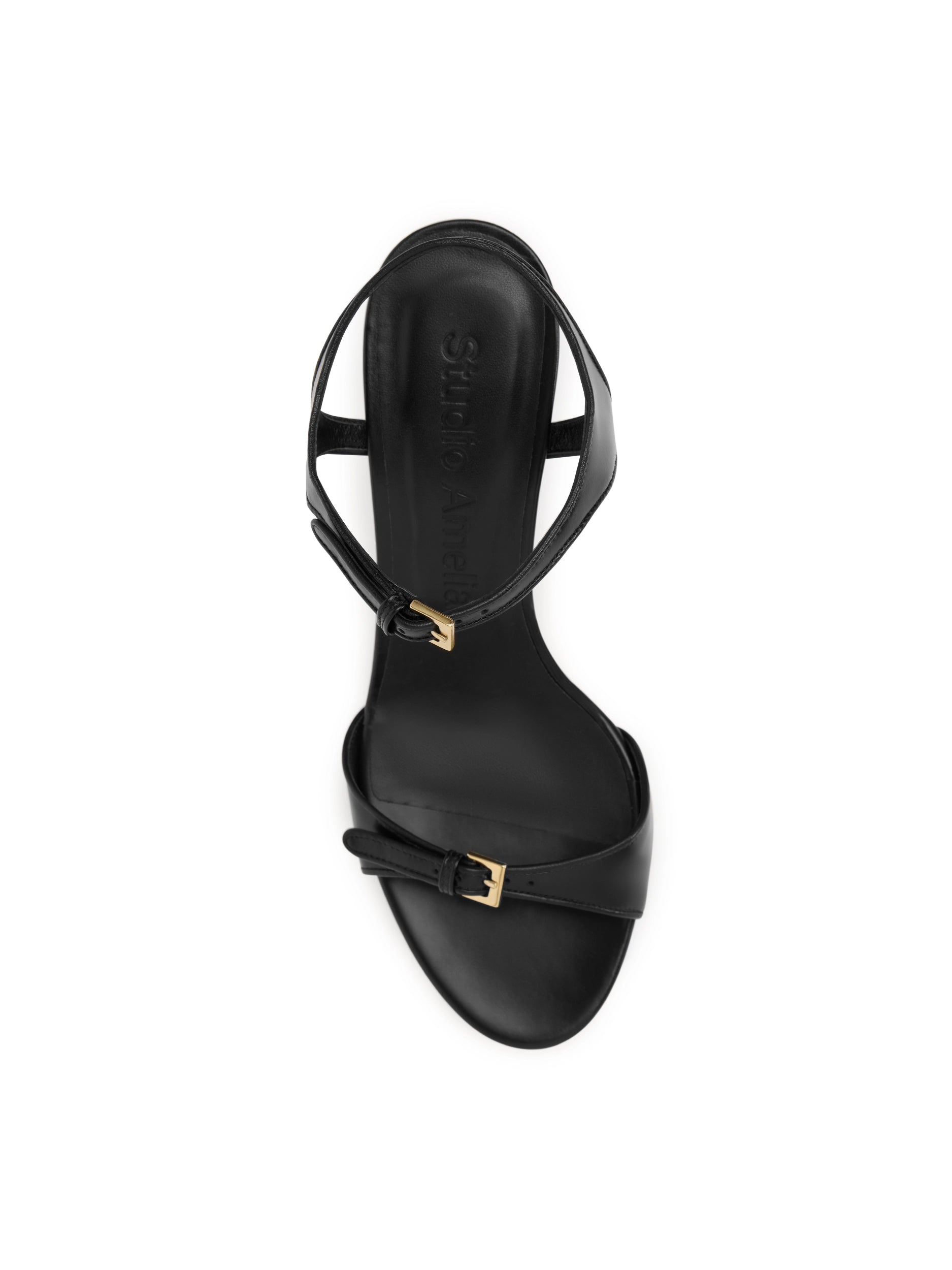 Black sandal with gold buckle on a white background