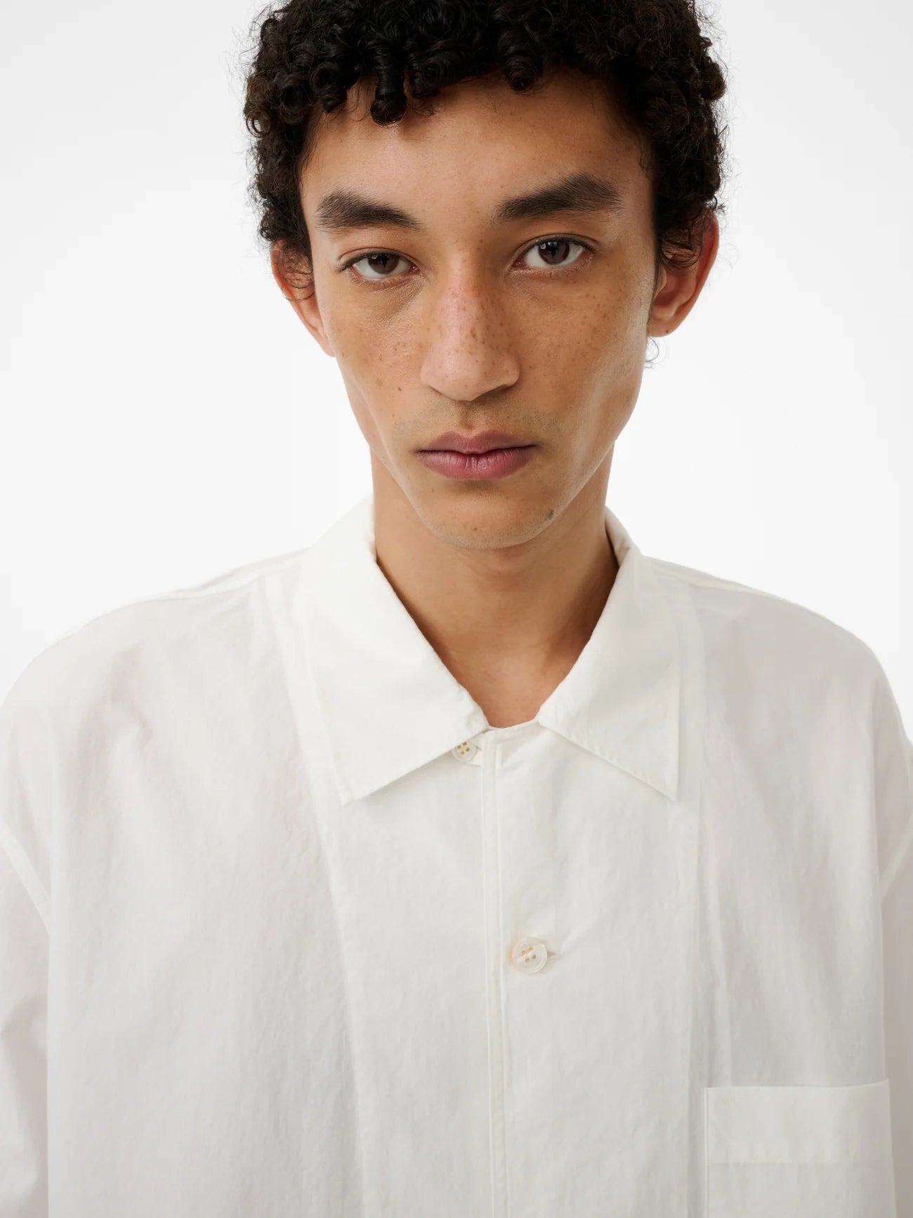 Man wearing a white shirt against a plain background
