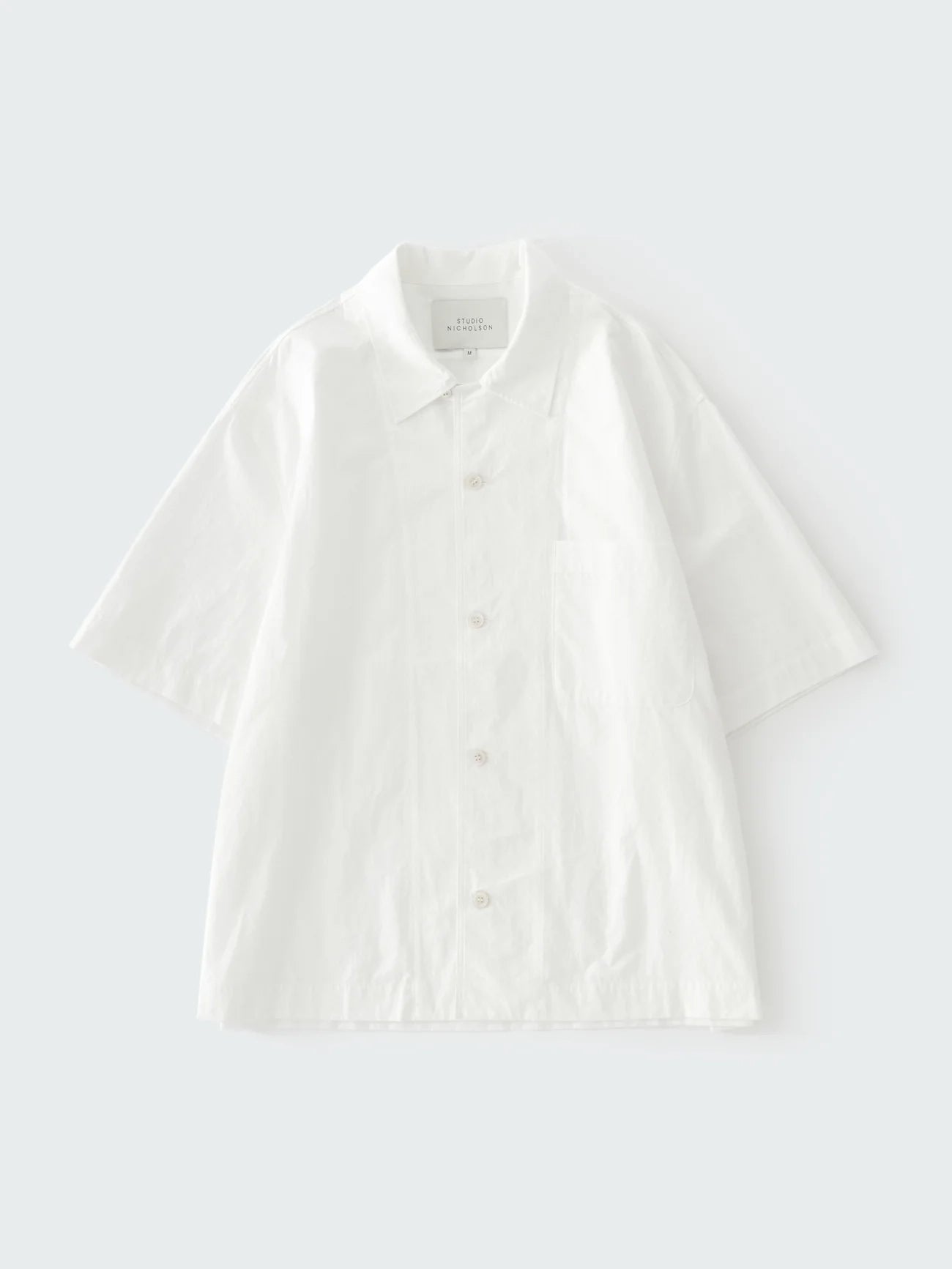 White polo shirt on a light gray background