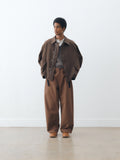 Studio Nicholson Balos pant in capucin with a wide, voluminous leg and relaxed fit, worn with a cropped jacket and layered knit, full length with clean drape.