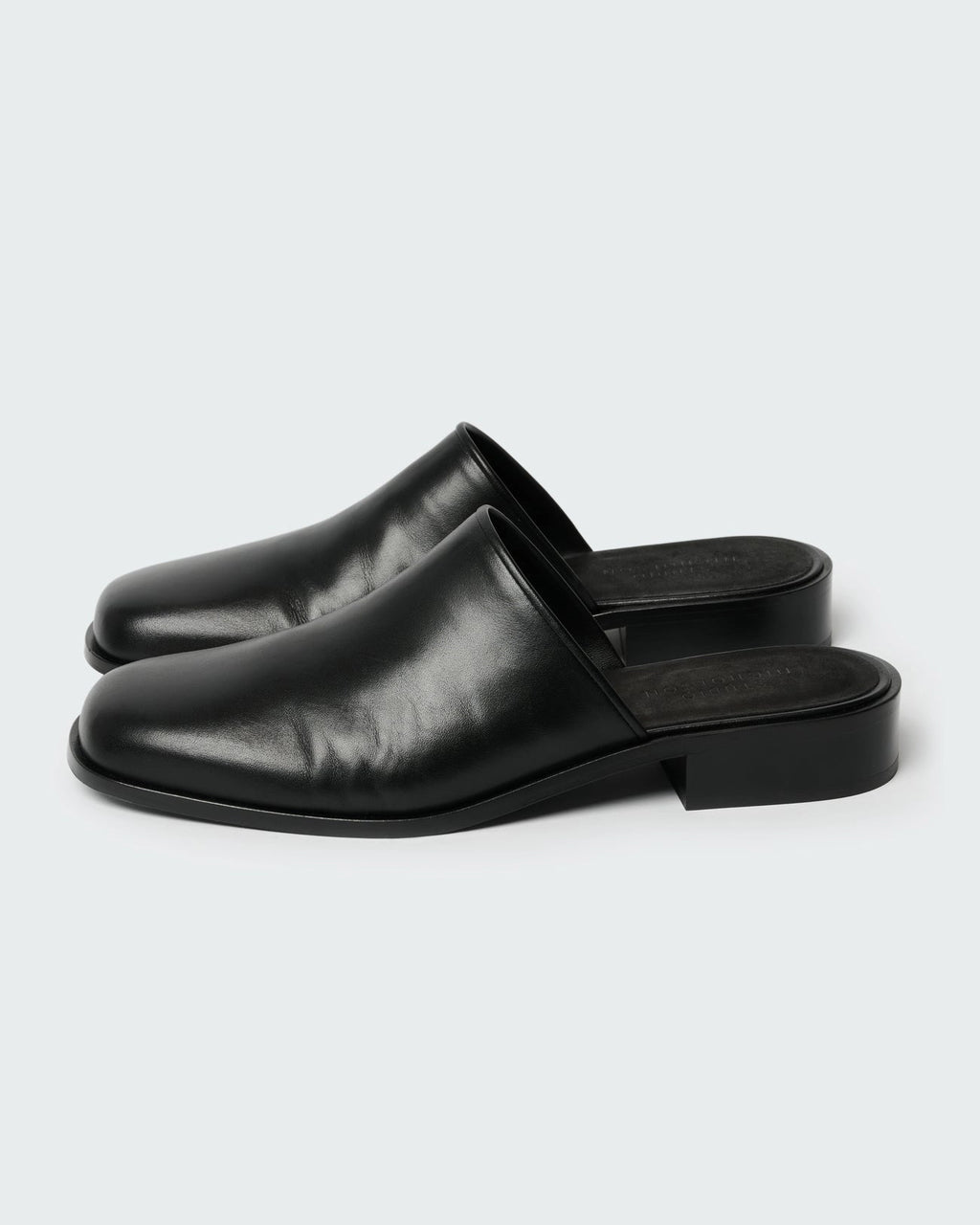 Studio Nicholson Barlow black leather mule with a slip-on design and low stacked heel.