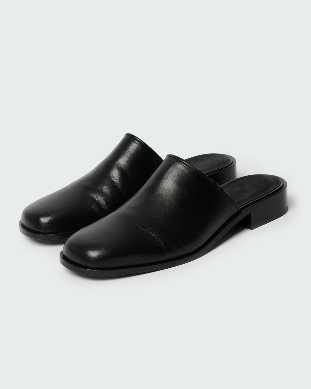 Studio Nicholson Barlow black leather mule with a slip-on design and low stacked heel.
