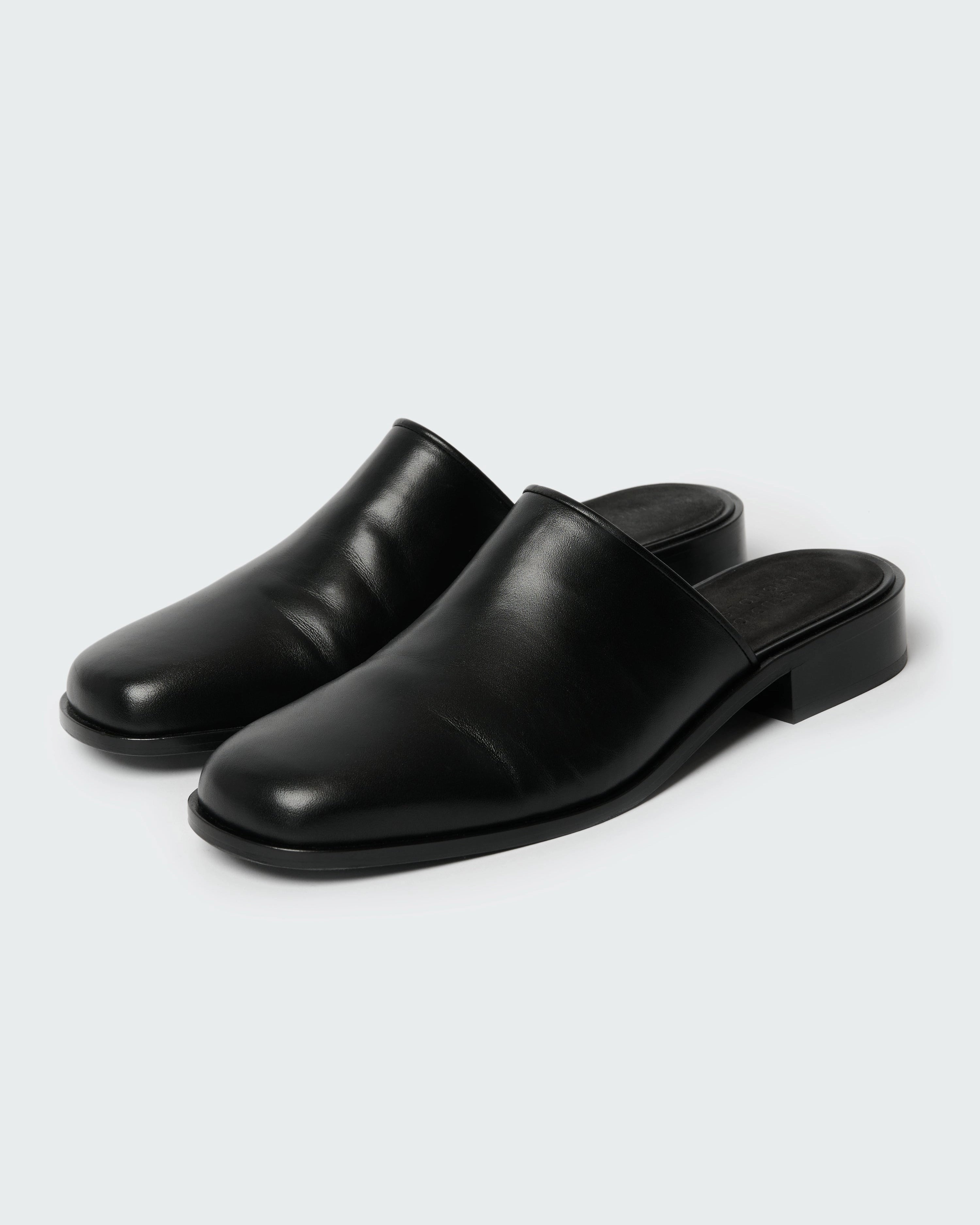 Studio Nicholson Barlow black leather mule with a slip-on design and low stacked heel.