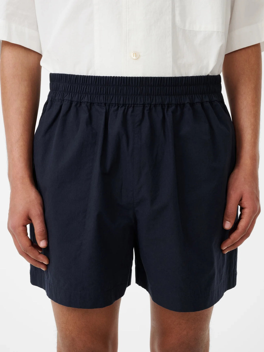 Person wearing navy shorts on a white background