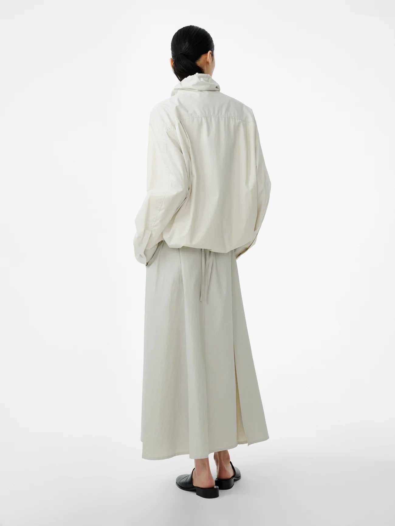 Person wearing a white outfit on a plain background