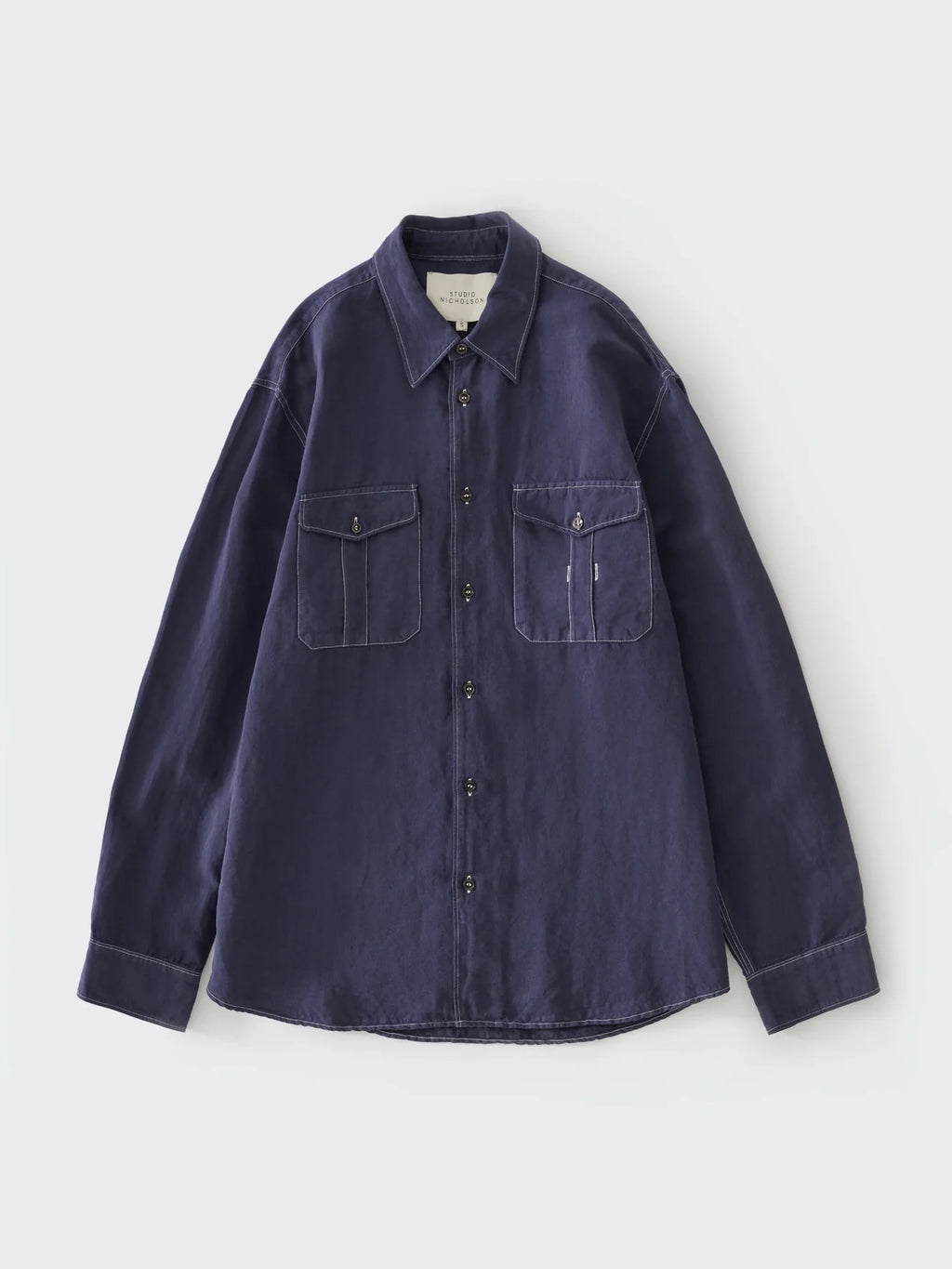 Navy blue shirt with two front pockets on a light gray background