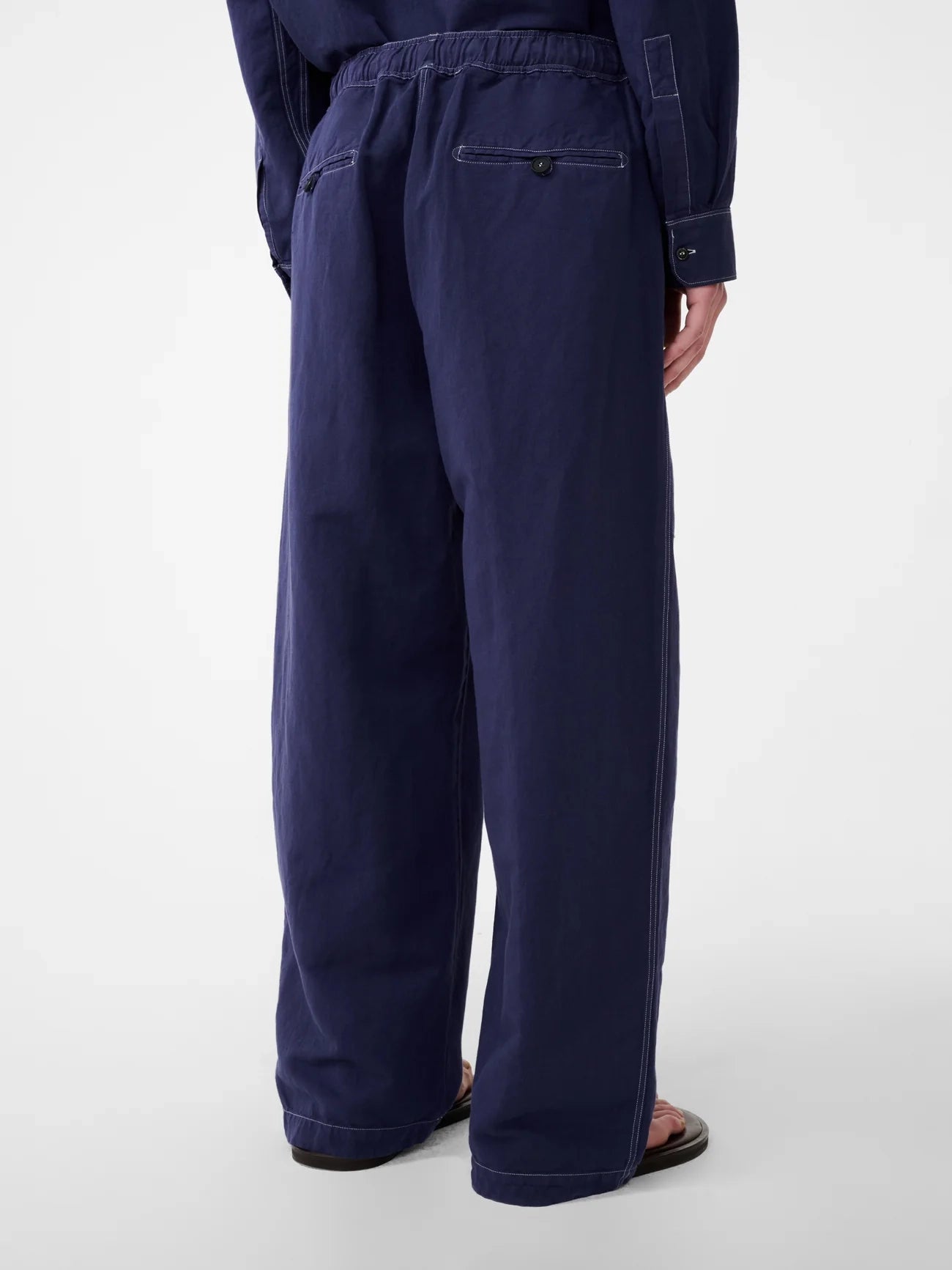 Navy blue pants worn by a person on a white background