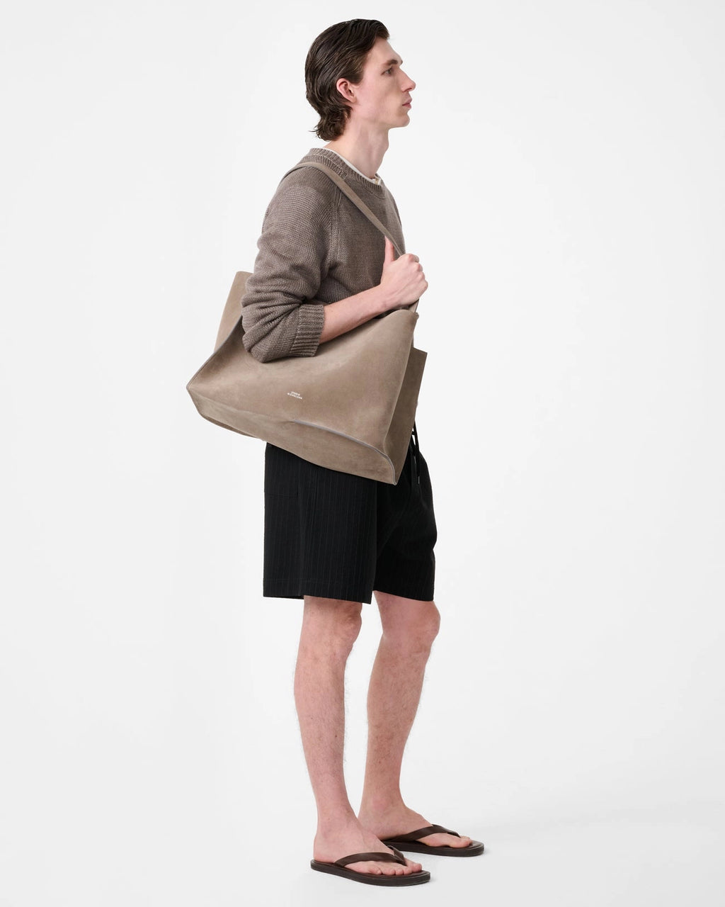 Model wearing Studio Nicholson Starboard black textured wool-cotton drawstring shorts with slip pockets and a back flap pocket.