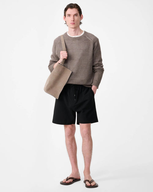 Model wearing Studio Nicholson Starboard black textured wool-cotton drawstring shorts with slip pockets and a back flap pocket.