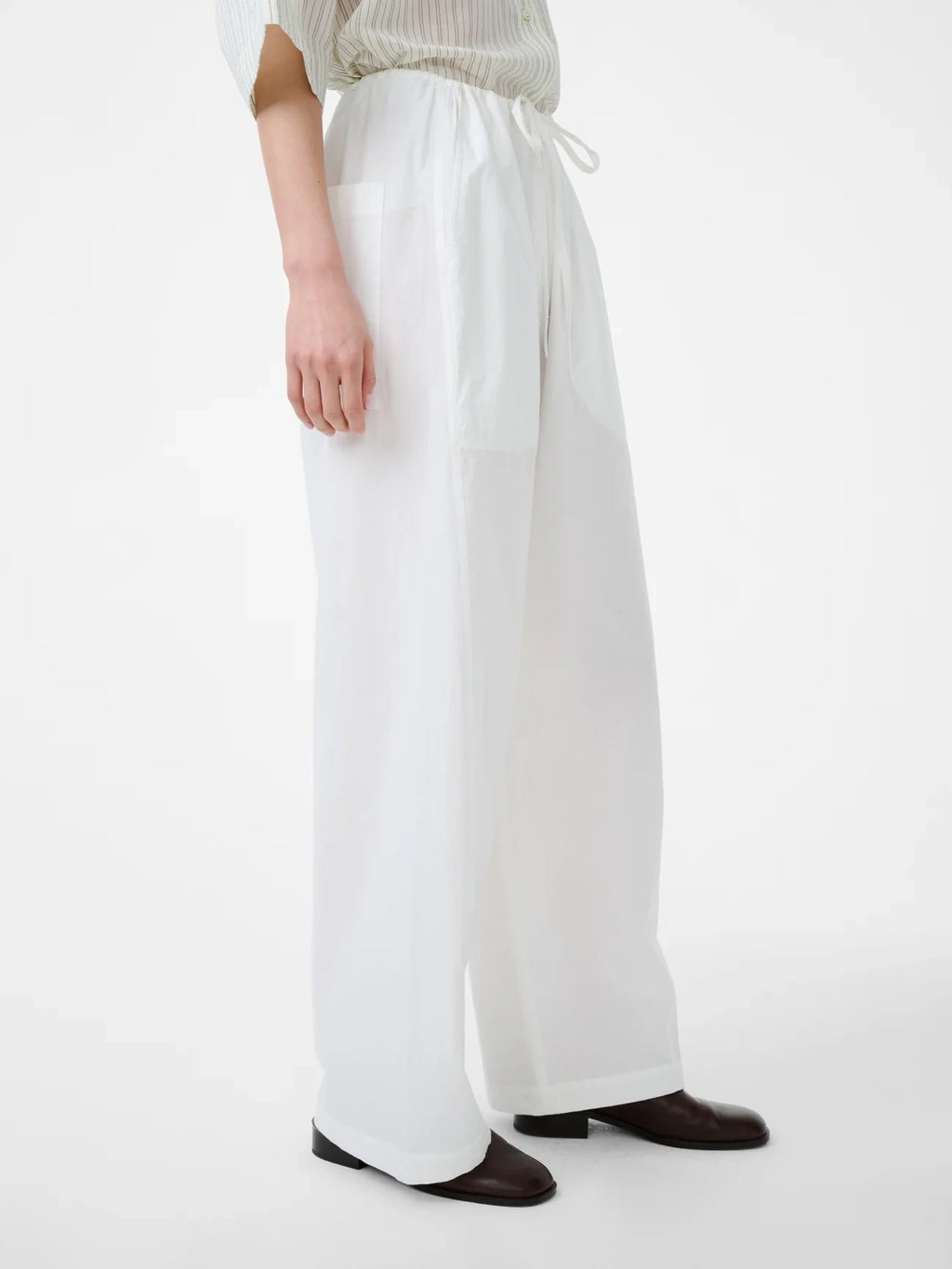 Person wearing white wide-leg pants on a white background