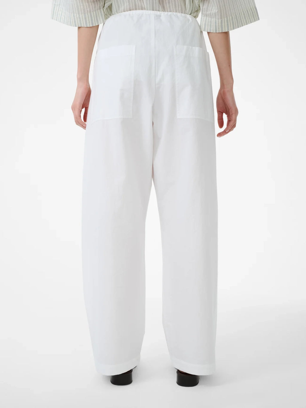 White pants worn by a person on a white background