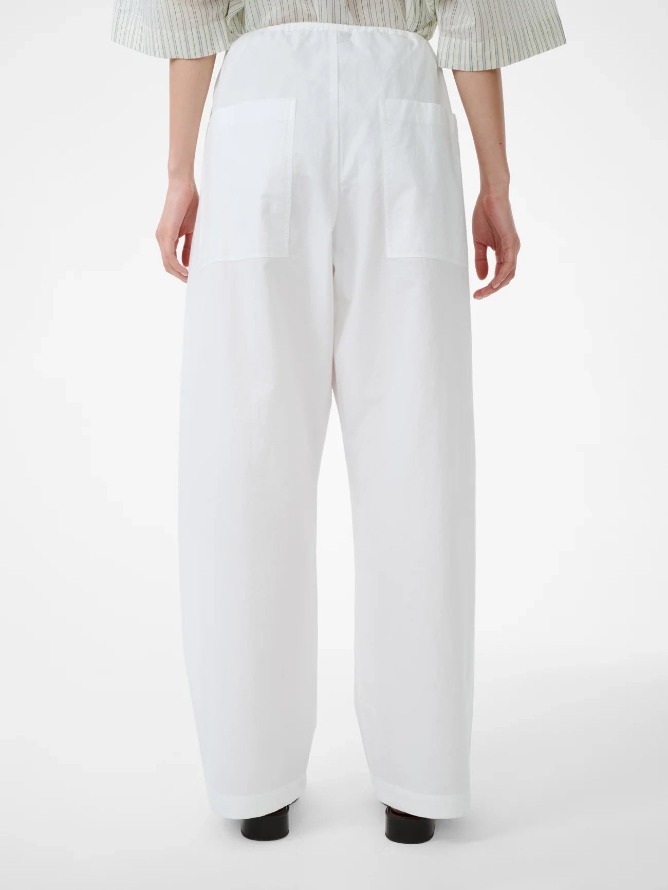 White pants worn by a person on a white background