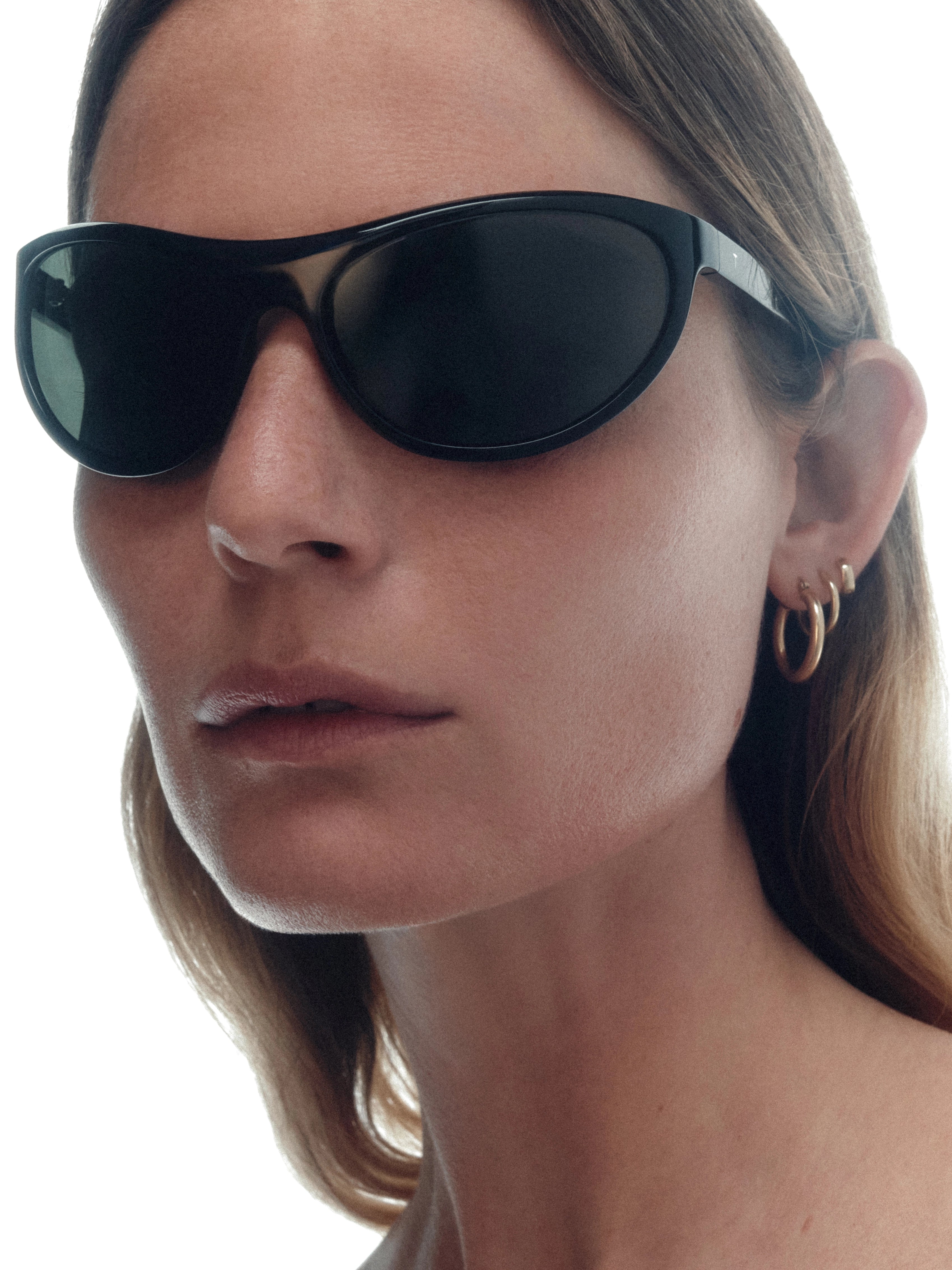 Model wearing THISTLES LEX sunglasses in black acetate with a narrow wrap silhouette and dark green G15 lenses.