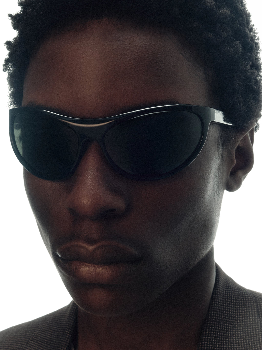 Model wearing THISTLES LEX sunglasses in black acetate with a narrow wrap silhouette and dark green G15 lenses.