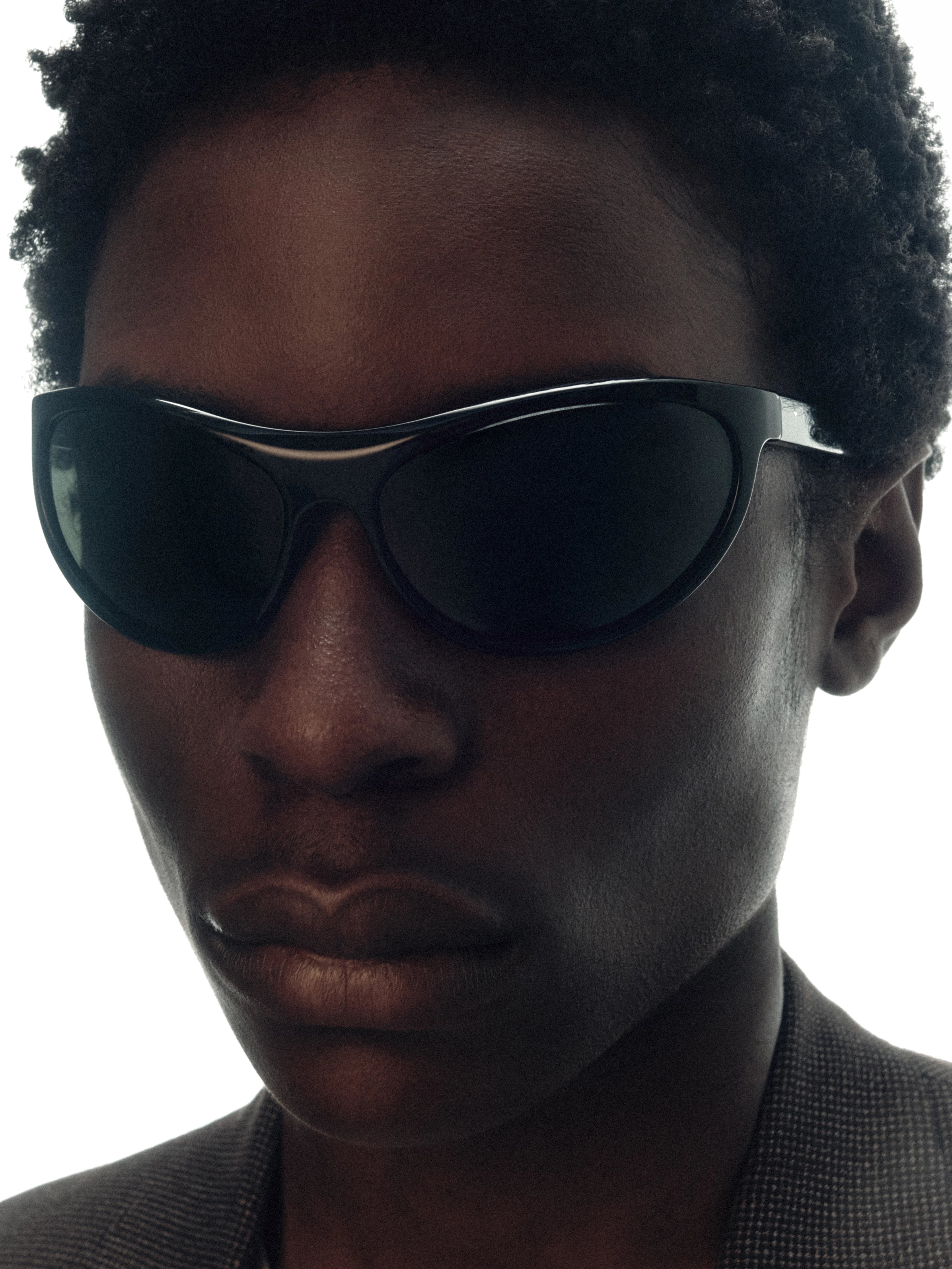 Model wearing THISTLES LEX sunglasses in black acetate with a narrow wrap silhouette and dark green G15 lenses.