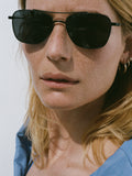 Model wearing THISTLES MALONE sunglasses in black titanium with a rectangular wire frame, double brow bar and dark lenses.